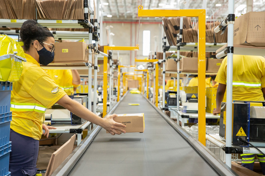 Funcionários do Mercado Livre trabalhando em centro logístico durante a operação da Black Friday no Brasil.