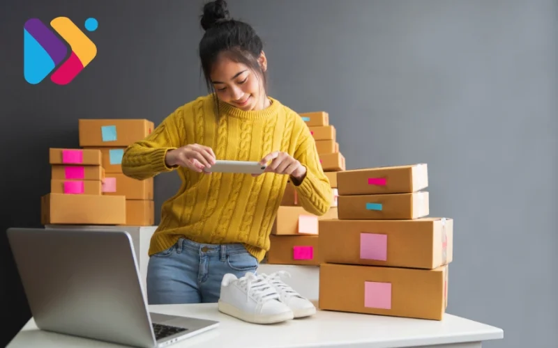 Pessoa iniciando vendas online com notebook e produtos organizados para envio